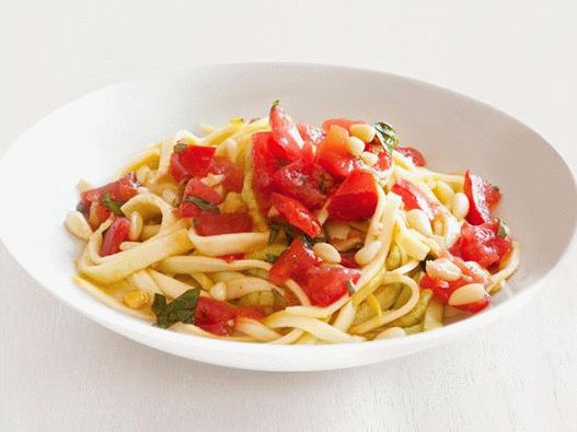 Снимка на макаронени феттучини от пресни тиквички с пикантен доматен сос с филийки