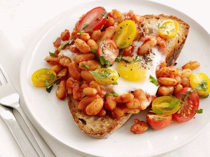 Снимка на запечени пържени яйца с боб и домати на тост